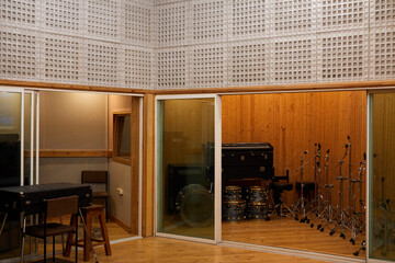 Background image of empty recording studio interior with musical instruments in glass booth, copy...