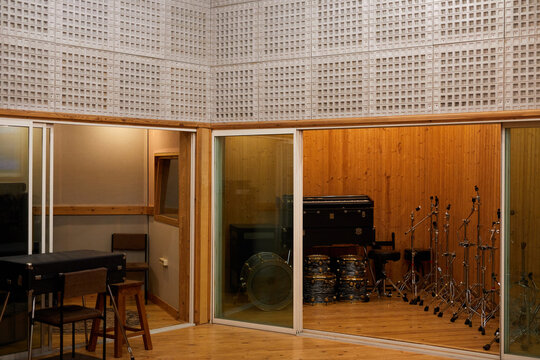 Background image of empty recording studio interior with musical instruments in glass booth, copy space