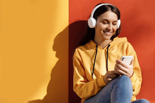 young smiling woman with headphones chating phone
