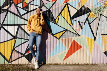 young smiling woman with headphones outdoor