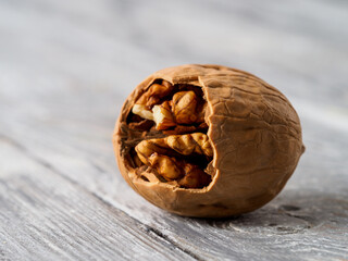 Walnut with shell on wooden background.