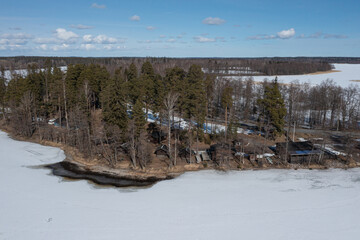 Obraz premium Landscape over a forest and a lake covered with ice and snow. Drone photo. Scandinavia. Finland.