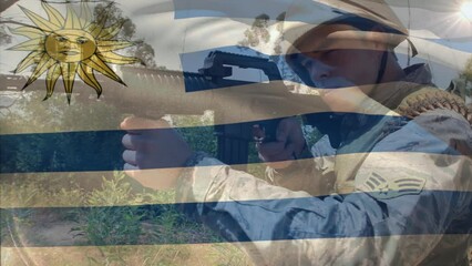 Animation of flag of uruguay over caucasian male soldier with weapon - Powered by Adobe