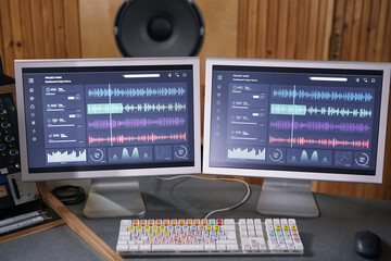 Background image of two computer screens with audio tracks in home recording studio, music...