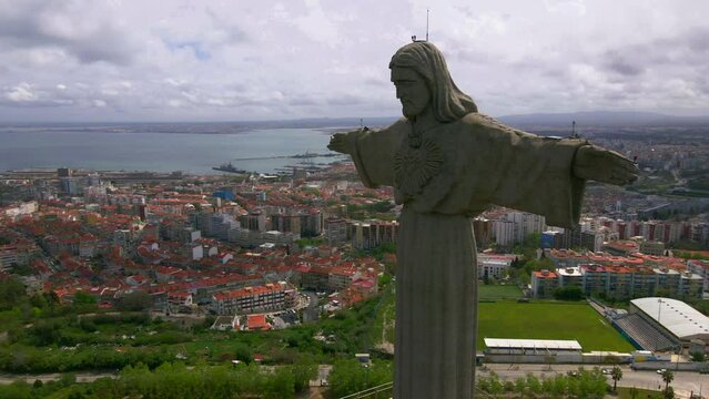 Christ the King Sanctuary in Almada. 25 de Abril bridge over Tagus river in background. Lisbon, capital of Portugal.
