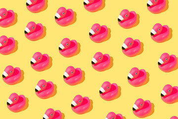 Summer pattern with rubber pink flamingos on yellow background.