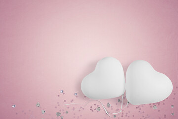 White heart shape party balloons and table confetti on a pink background with copy space