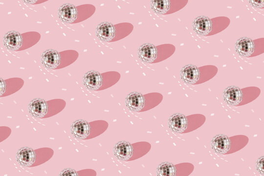 Party patern with shiny disco balls on pink background.