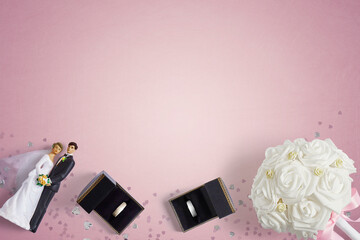 Bride and Groom gold and white gold wedding rings in there boxes on a pink background