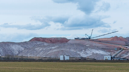 Fototapeta premium Giant spreader or absetzer machinery. A large dumper on a landfill with potash ore. Extracting potassium salts.