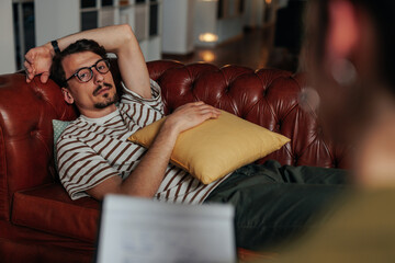 Obraz premium Unhappy young man carefully listens to his therapist