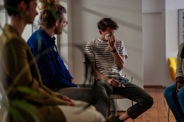 Crying young man in support group