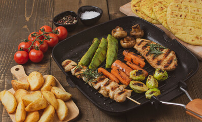 Grilled chicken steak with different  vegetables on a pan. Top view, flat lay