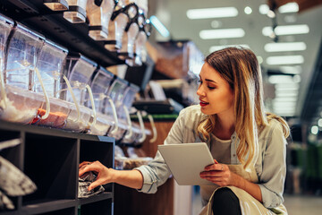 Female owner checking inventory via tablet