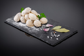 dumplings on a black tray against dark background