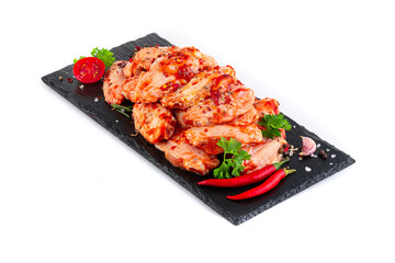 Сhicken wings in marinade on a black plate