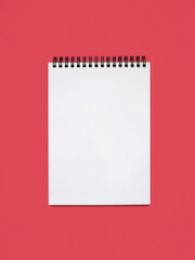 Notebook made of white paper with binding on a pink background. Blank notepad with free space for text. Notebook in classic binding without notes on vertical photo