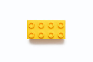 Yellow plastic detail on a white background. One detail of the constructor is isolated on a white background in the center of the frame close-up