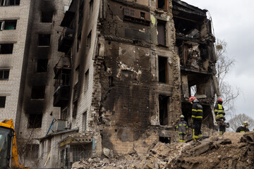 Bomberos trabajan en la limpieza de escombros y rescate de cuerpos de un edificio habitacional que fue destruido por un misil ruso en Bodoryanca Ucrania. - obrazy, fototapety, plakaty
