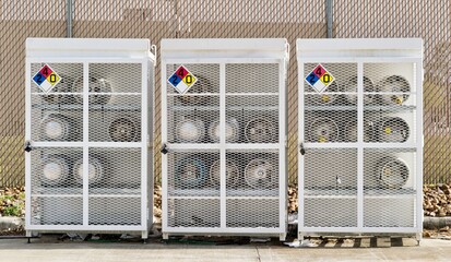 Liquified Petroleum gas cylinders stored horizontally in a metal safety cage with NFPA warning...