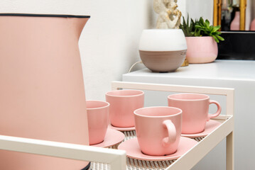 Set of pink porcelain cups with matching saucers and a matching colored kettle