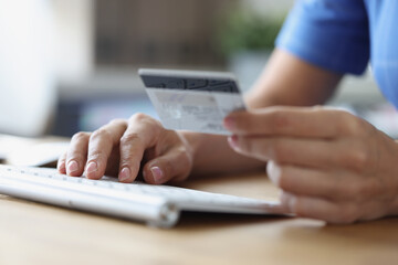 Fototapeta premium Person holds credit bank card and computer keyboard