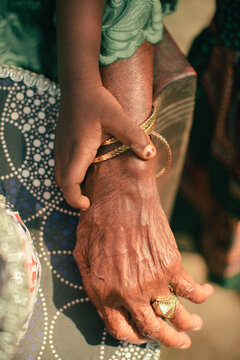 Hands of a young child holding an elderly hand