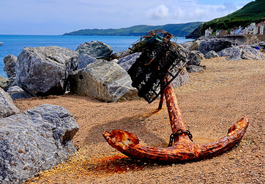 An old rusty anchor on the pebbled beach at Beesands