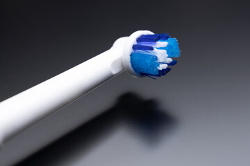 Electric toothbrush on a dark background, replaceable tips on the toothbrush