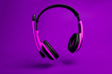 pink headphones on violet background 