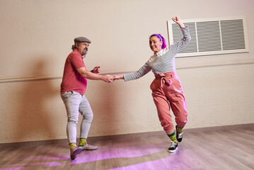A senior adult couple dancing Lindy Hop in a studio