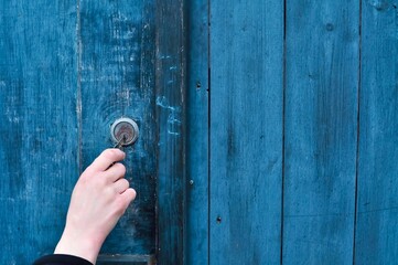 hand opening lock on wooden blue door 
