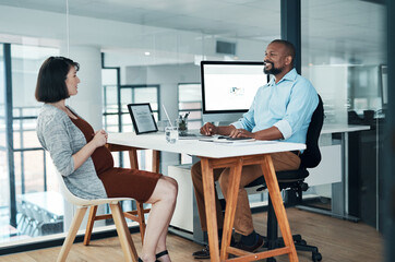 Great ideas come up in conversations. Cropped shot of two young businesspeople sitting in the office together and having a discussion.