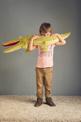 I just caught me a big old gator. Studio portrait of an adorable little boy playing with a...