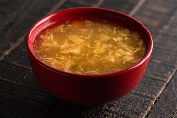 Egg drop soup isolated on a wooden table