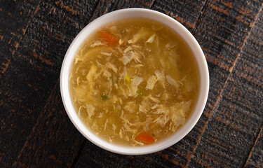 Egg drop soup isolated on a wooden table