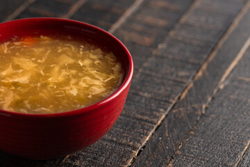 Egg drop soup isolated on a wooden table