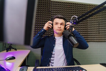 serious radio host broadcasts live reads news on computer screen.