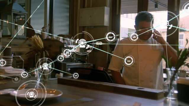 Animation of network of connections with icons over biracial businessman using smartphone