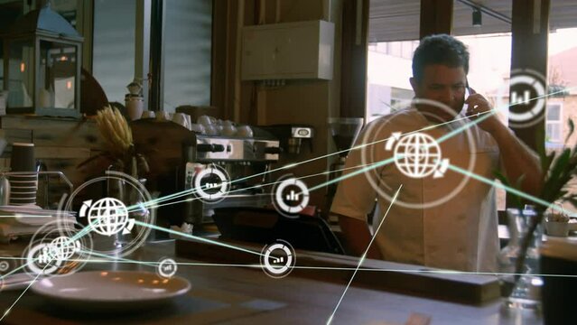 Animation of network of connections with icons over biracial businessman using smartphone
