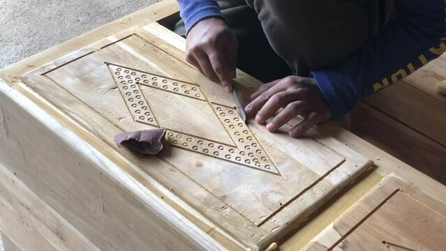 a craftsman is carving a wooden table in a workshop