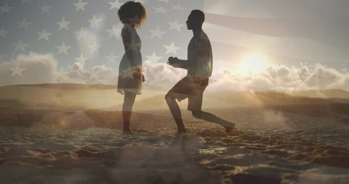 Animation of flag of united states of america over biracial man proposing to his girlfriend on beach