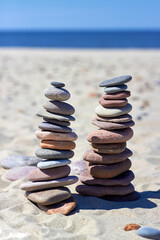 Two pyramid of stones on a sandy beach. Zen balance stones.