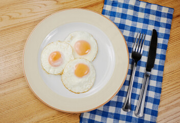 fried scrambled eggs from three eggs on a wooden table