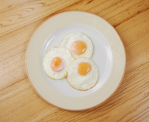 fried scrambled eggs from three eggs on a wooden table
