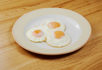 fried scrambled eggs from three eggs on a wooden table