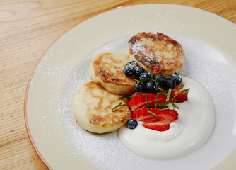 syrniki pancakes with strawberries and blue berries
