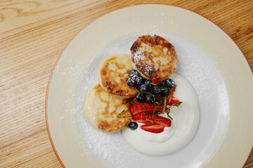 syrniki pancakes with strawberries and blue berries