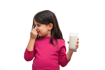 Little girl who doesn't want to drink milk on a white background