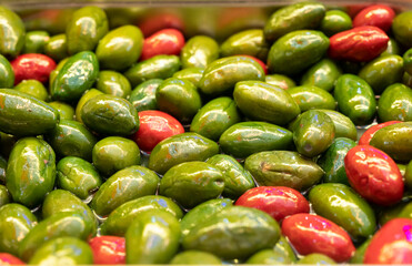 Green fresh green and red olives close up on market, food background